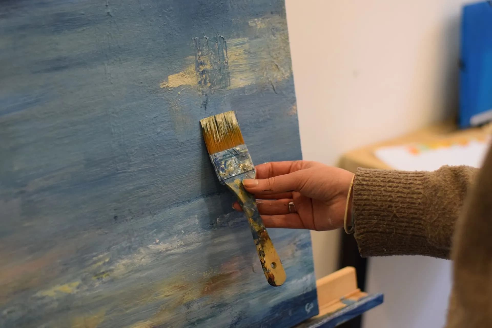 Le pinceau de Claire Prevost posé sur une toile en cours, à l'atelier